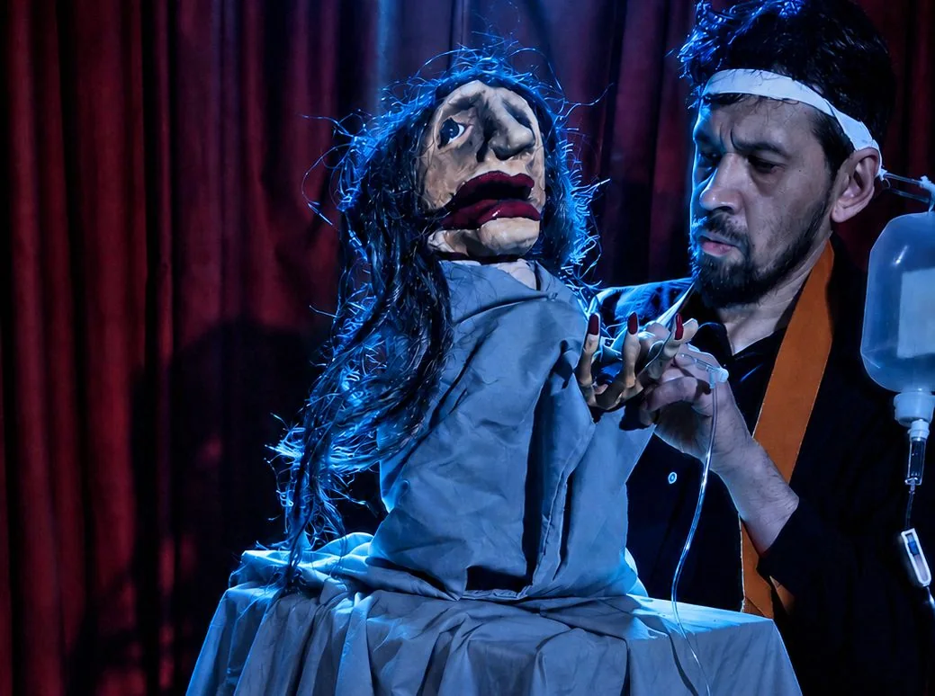 Una marioneta y su manipulador en escena