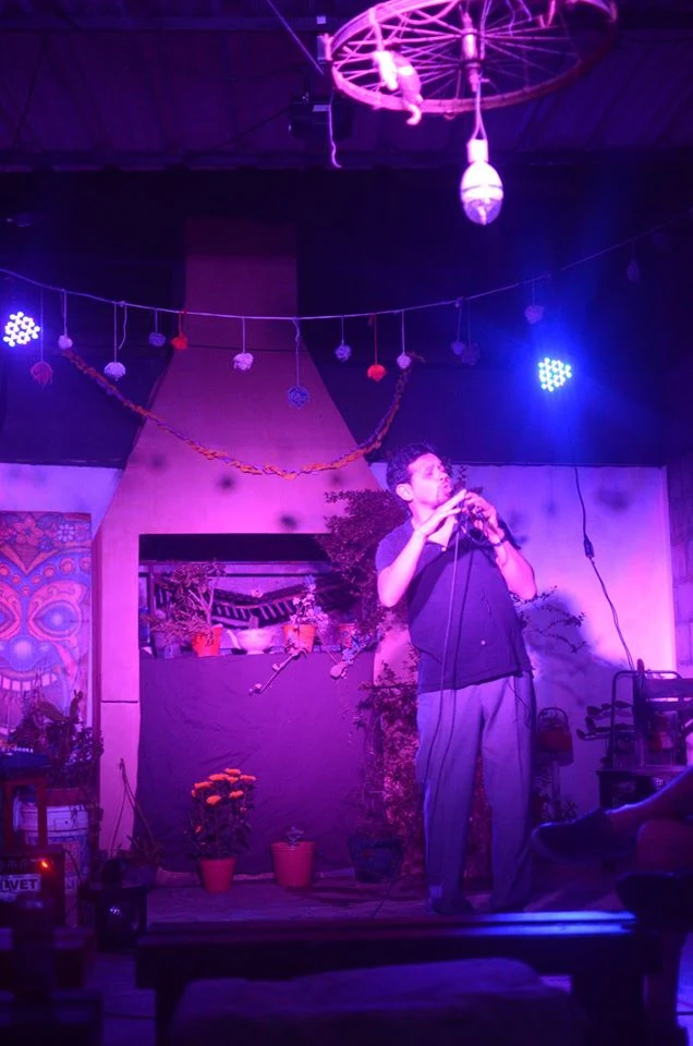 El actor junto a una chimenea, bajo iluminación violeta