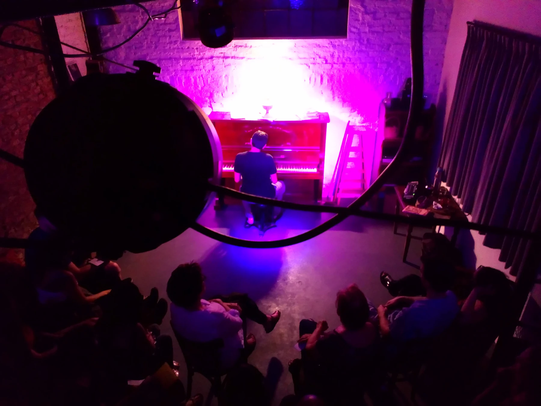 El actor al piano con el público alrededor